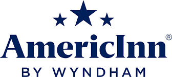 The AmericInn by Wyndham logo features "AmericInn" in bold blue text with three blue stars above, and "BY WYNDHAM" written below in smaller capital letters, capturing the classic look of AmericInn Lodge branding.