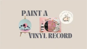 A painted vinyl record with a sunset and palm trees sits on an easel surrounded by painting supplies and a pink floral vinyl record, inviting you to a Vinyl Record Paint Party at 22 Northmen Brewing. Features "Paint a Vinyl Record" and "The Palette District" logo. vinyl record paint party