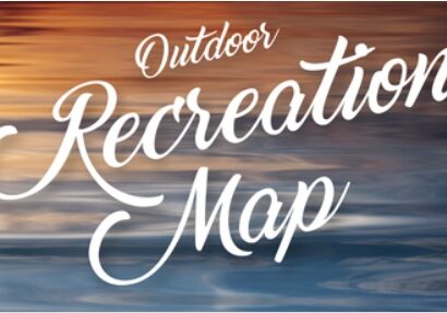 Text reading "Alexandria Area Lakes Recreation Map" in white, cursive script over a blurred background of warm and cool colors resembling a sunset over water.